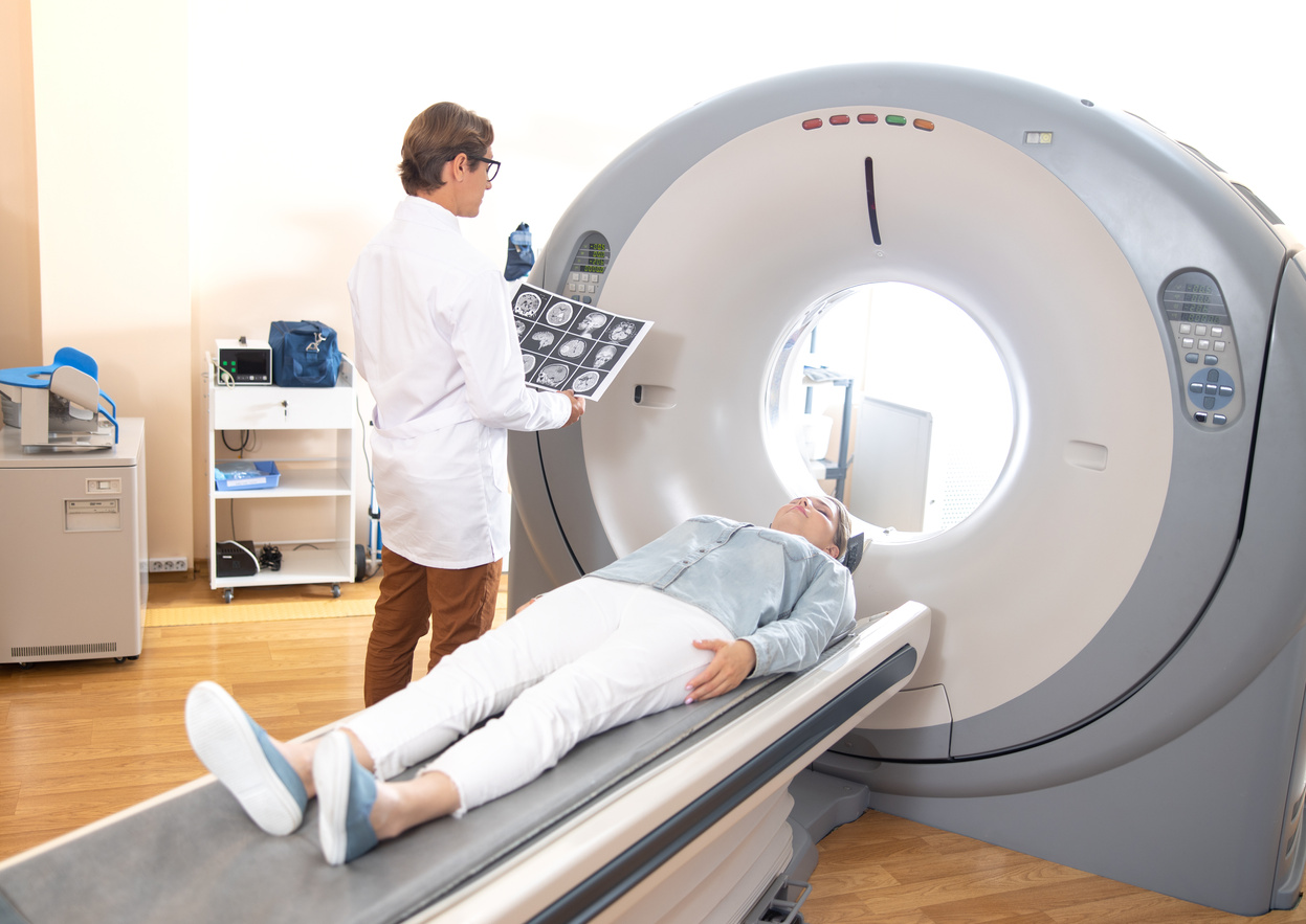 Radiology technologist examining brain CT scan of patient