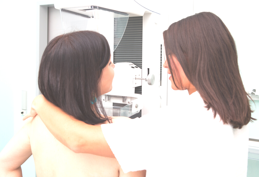 Nurse with young women having a mammogram