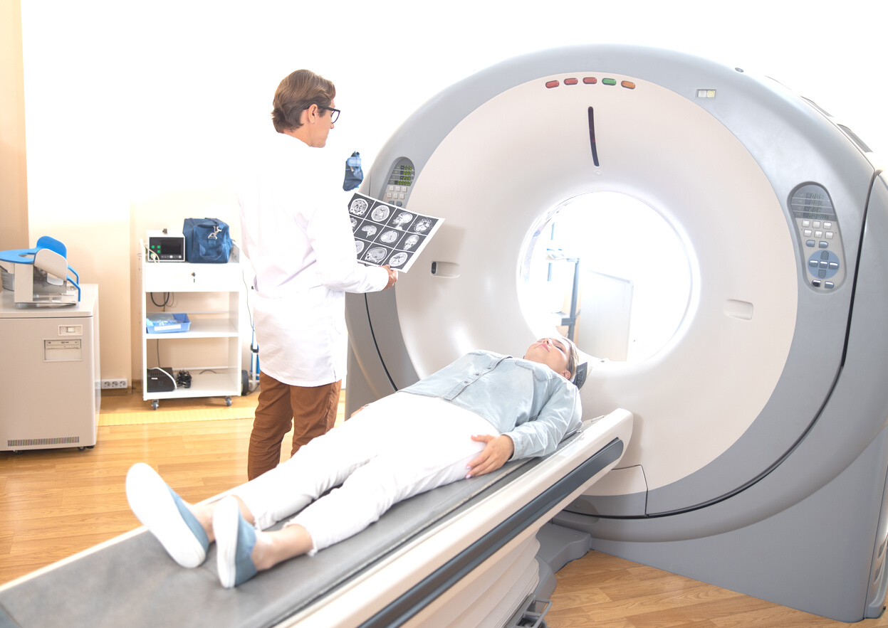 Radiology technologist examining brain CT scan of patient
